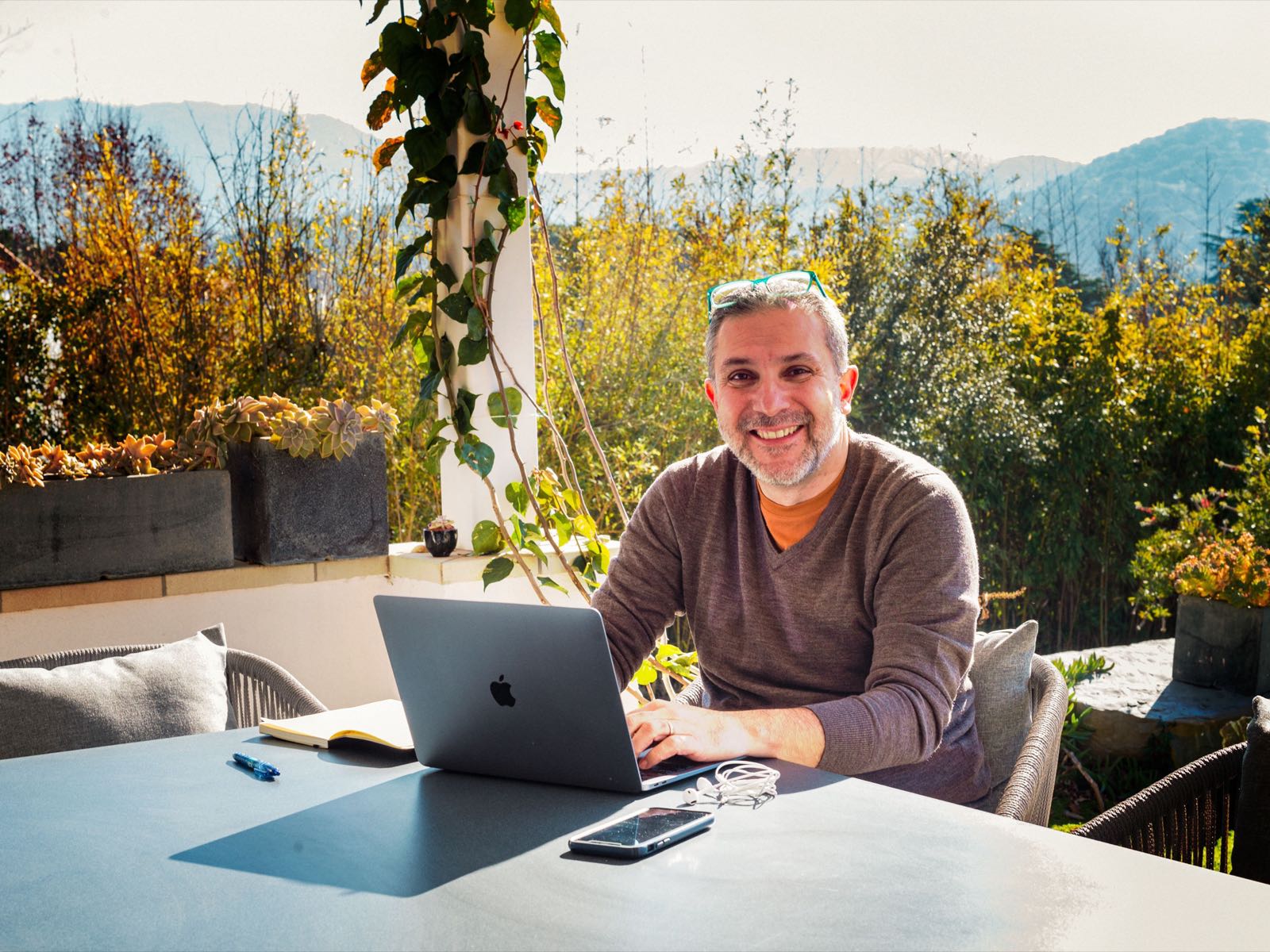 John Arboleda working outdoors, mountains behind him